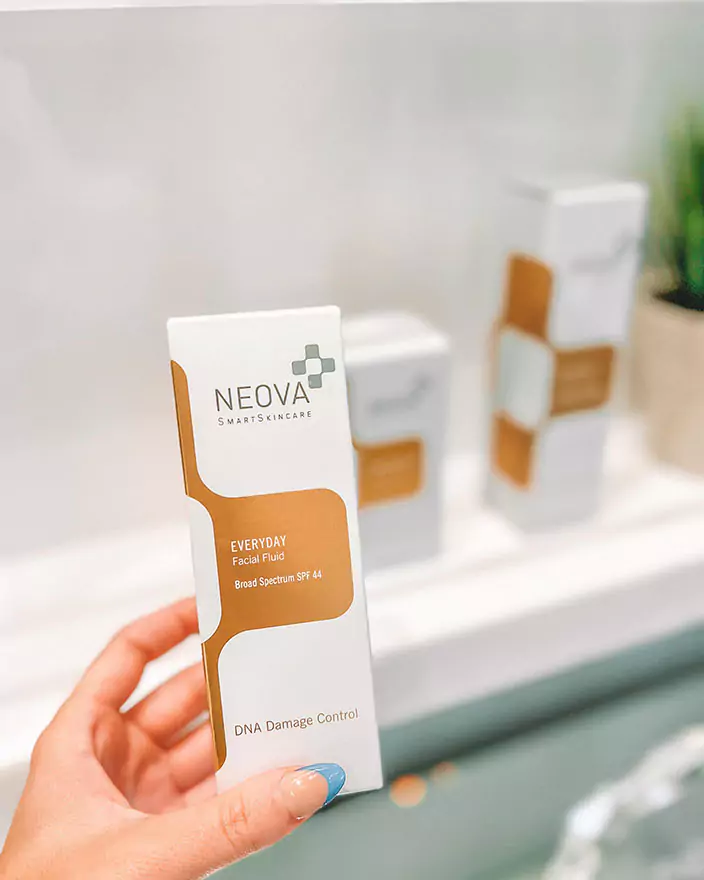 Hand holding a Neova SmartSkincare Everyday Facial Fluid with SPF 44